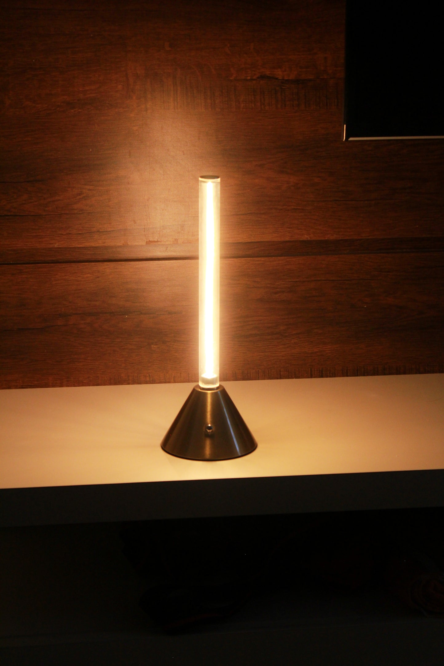 Metal Touch Modern table lamp with a cone-shaped base on a wooden surface