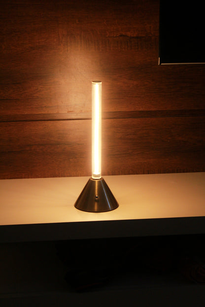 Metal Touch Modern table lamp with a cone-shaped base on a wooden surface