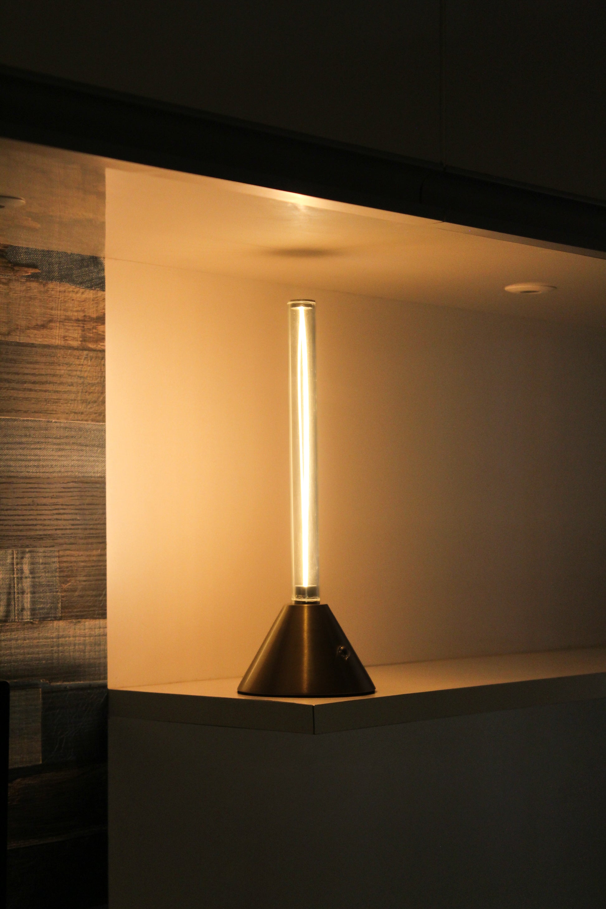 Metal Touch Modern floor lamp with a cylindrical design on a dark surface.