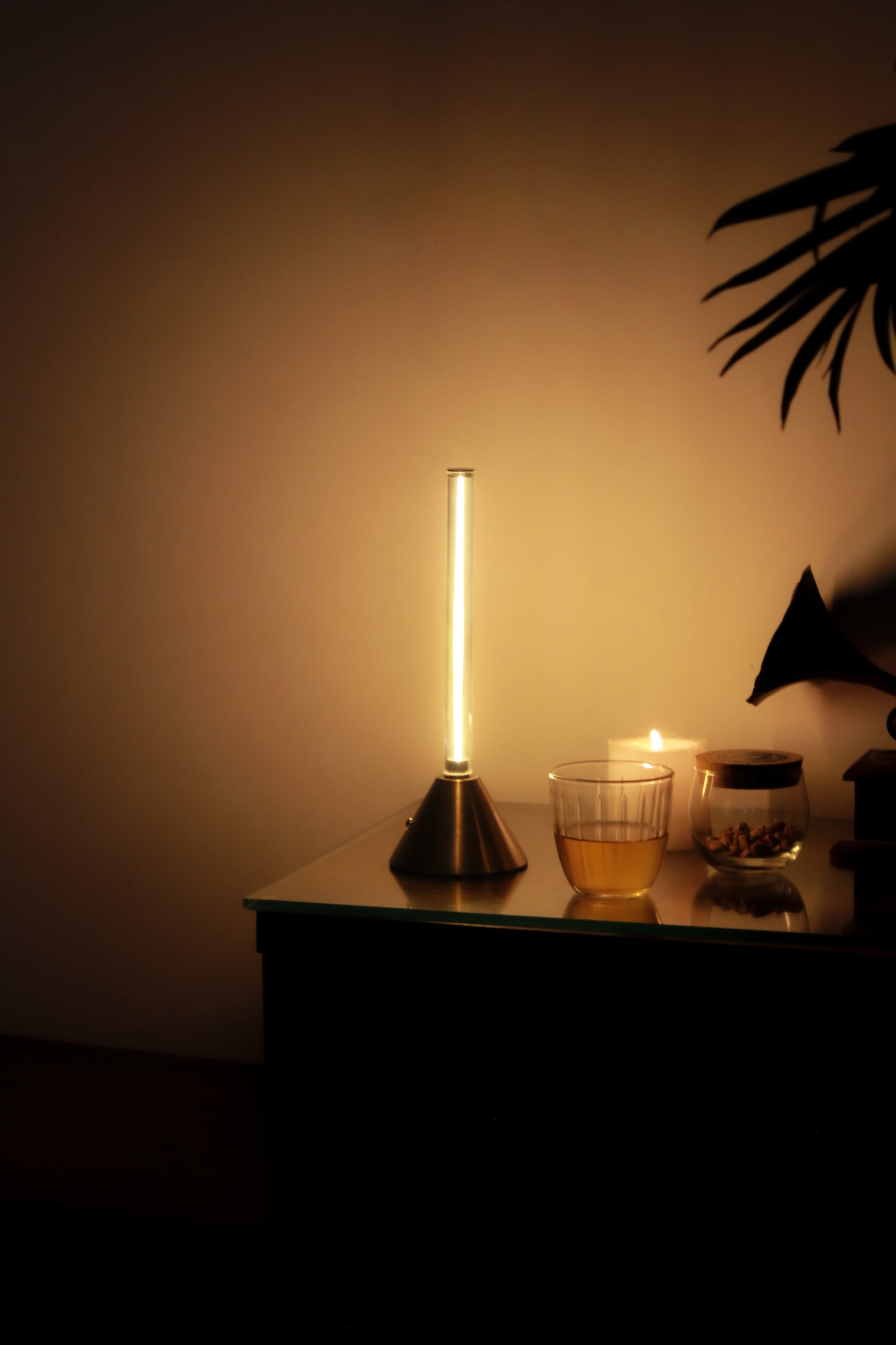 Metal Touch Modern table lamp on a side table with a warm glow in a dimly lit room.