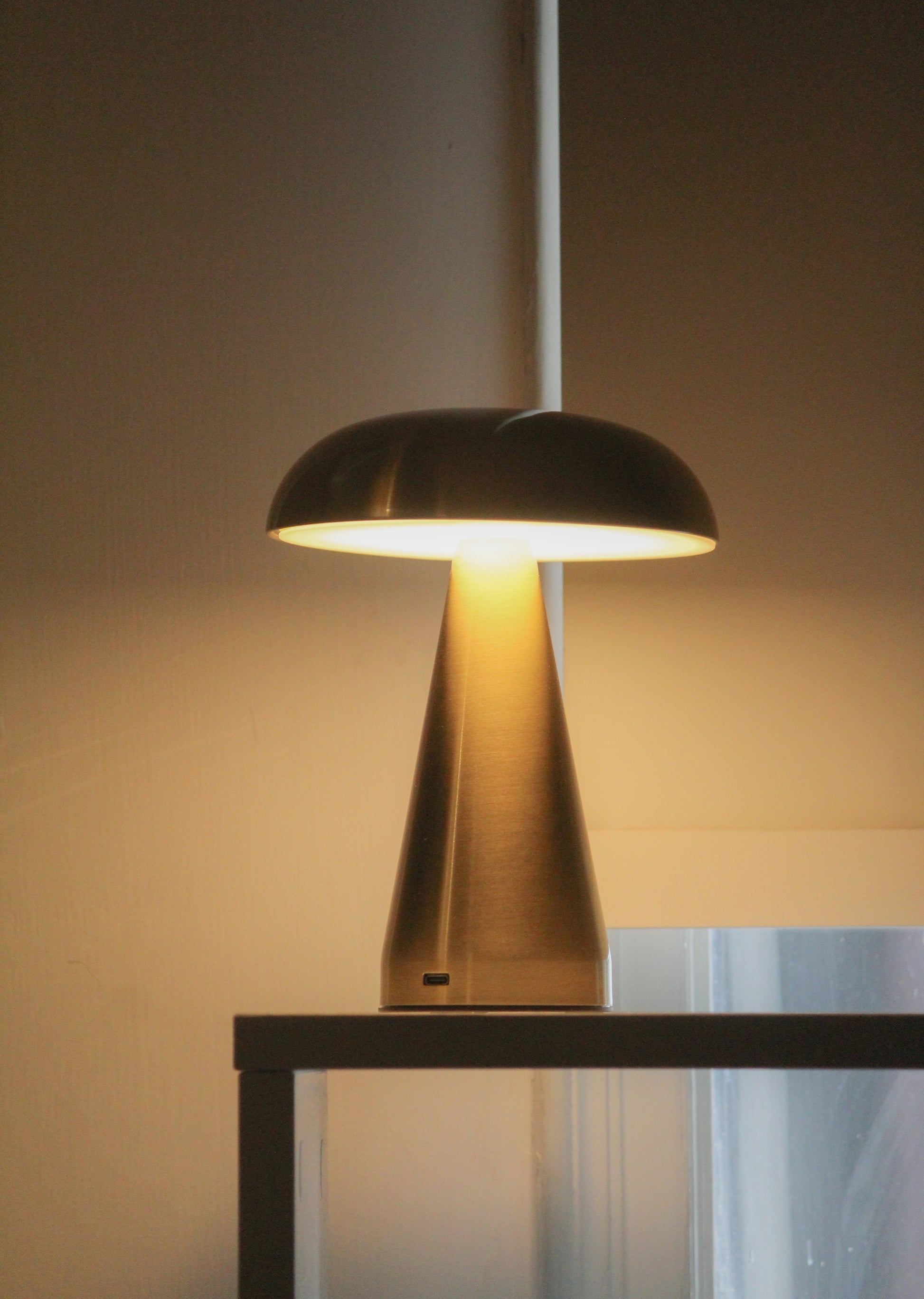 Symmetrical shot of the Mushroom lamp's signature dome shade and slim gold stem.