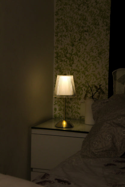 The Prism Glaze lamp on a marble console table, highlighting its portable, cordless design.