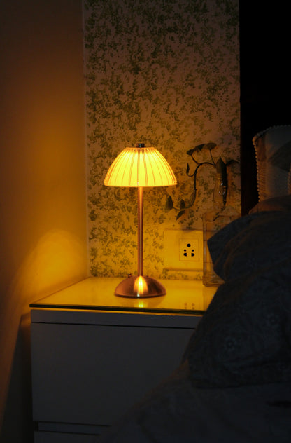 Aura Ember by Garnish, a luxury champagne brass cordless lamp providing a warm ambient glow.