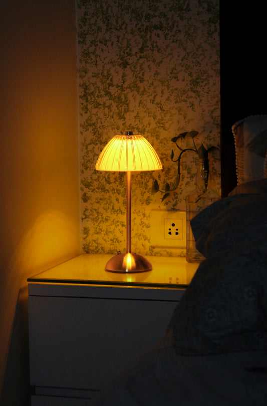 Aura Ember by Garnish, a luxury champagne brass cordless lamp providing a warm ambient glow.